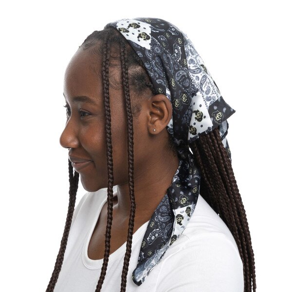 This is a picture of the bandana being worn as a headband. It shows the alternating squares of black and white paisley and black and gold C.U. buffalo logos over white backing.